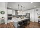 Modern kitchen with white cabinets, stainless steel appliances, mosaic backsplash, and a large center island at 14102 Night Owl Ln, Parker, CO 80134