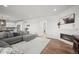 Open living room with fireplace, modern sectional sofa, and hardwood floors adjacent to kitchen at 14102 Night Owl Ln, Parker, CO 80134
