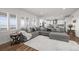 Spacious living room with large gray sectional, white rug, and bright windows with plantation shutters at 14102 Night Owl Ln, Parker, CO 80134