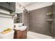 Updated bathroom with modern vanity, sleek fixtures, dark tile shower, and ample storage shelves for a contemporary touch at 3638 N Elizabeth St, Denver, CO 80205