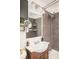 Clean bathroom featuring a pedestal sink, wall-mounted mirror and shelves, complemented by modern lighting and fixtures at 3638 N Elizabeth St, Denver, CO 80205