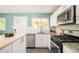 Bright kitchen with stainless steel appliances, granite counters, and white cabinetry at 3638 N Elizabeth St, Denver, CO 80205