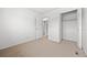 Bedroom with neutral carpet near a closet featuring hinged doors and built-in shelves at 1188 S Troy St, Aurora, CO 80012