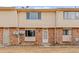 A brick and vinyl exterior of a townhome with a small patch of dry grass in front at 1188 S Troy St, Aurora, CO 80012