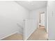 Hallway with carpet leading to a bathroom with a white door and tiled walls at 1188 S Troy St, Aurora, CO 80012