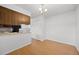 Kitchen featuring laminate floors, wood cabinets, and access to the dining area at 1188 S Troy St, Aurora, CO 80012