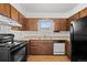 Traditional kitchen featuring wood cabinets, laminate counters, and classic appliances at 1188 S Troy St, Aurora, CO 80012