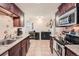 Kitchen with dark wood cabinets, granite counters, and appliances at 1517 S Owens St # 7, Denver, CO 80232