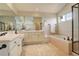 Primary bathroom with double sinks, large mirror, and a separate tub, offering a relaxing retreat at 8101 E Dartmouth Ave # 22, Denver, CO 80231