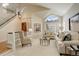 Bright living room with vaulted ceilings, large windows, and an open layout leading to the staircase at 8101 E Dartmouth Ave # 22, Denver, CO 80231