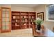 Home office with a wall of built-in bookshelves and natural light at 8101 E Dartmouth Ave # 22, Denver, CO 80231