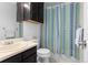 Compact bathroom featuring a sink, toilet, and shower with patterned curtain at 18982 E 46Th Ave, Denver, CO 80249