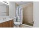 Bathroom featuring a wood vanity sink and walk-in shower with tan tile and pebble flooring at 18982 E 46Th Ave, Denver, CO 80249