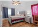 Bedroom featuring wood floors, ceiling fan, and two windows with curtains at 18982 E 46Th Ave, Denver, CO 80249