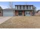 Charming two-story home boasts a well-maintained lawn, brick accents, and a welcoming entrance at 18982 E 46Th Ave, Denver, CO 80249