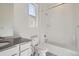 Bathroom with a combined shower and tub, white tiling, and a dark vanity at 7171 Waterleaf Trl, Littleton, CO 80125