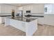 Modern kitchen with stainless steel appliances and a large kitchen island with light wood flooring at 7171 Waterleaf Trl, Littleton, CO 80125