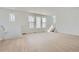 Open-concept living room with light wood floors, bright windows, and staircase in view at 7171 Waterleaf Trl, Littleton, CO 80125