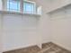 Walk-in closet with neutral carpet, white walls, and metal hanging racks with above window at 7171 Waterleaf Trl, Littleton, CO 80125