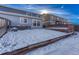 View of backyard with snow, retaining wall, and deck at 5780 Raleigh Cir, Castle Rock, CO 80104