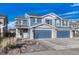 Two-story house with blue siding, stone accents, and a three-car garage at 5780 Raleigh Cir, Castle Rock, CO 80104