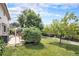 Spacious backyard with mature trees, grassy lawn, and patio at 3317 S Elkhart St, Aurora, CO 80014