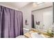 Clean bathroom with purple shower curtain, updated vanity, and large mirror at 3317 S Elkhart St, Aurora, CO 80014