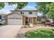Two-story house with a brick front, attached garage, and landscaped yard at 3317 S Elkhart St, Aurora, CO 80014