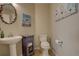 Charming powder room featuring pedestal sink, toilet, and decorative artwork at 23500 Bent Oaks Way, Parker, CO 80138