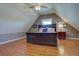 A bedroom with hardwood floors and a ceiling fan features a large bed, nightstand, and window at 23500 Bent Oaks Way, Parker, CO 80138