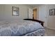 This bedroom features neutral walls and carpet, with an attached bathroom and closet, and an inviting, patterned duvet at 23500 Bent Oaks Way, Parker, CO 80138