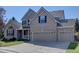 Attractive two-story brick home featuring a three-car garage, front porch, and a well-manicured lawn at 23500 Bent Oaks Way, Parker, CO 80138