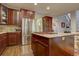 Island kitchen featuring stainless steel appliances, wooden floors, and stone backsplash at 23500 Bent Oaks Way, Parker, CO 80138