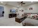 A cozy living room with a ceiling fan, large TV, comfortable grey sofa, and neutral colored carpet at 23500 Bent Oaks Way, Parker, CO 80138