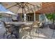 An outdoor entertaining area features a large bar with seating, patio umbrella, and a cozy seating area by the home at 23500 Bent Oaks Way, Parker, CO 80138