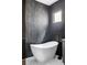 Modern bathroom featuring a sleek, freestanding bathtub with black fixtures and stylish dark tile walls at 4363 W 118Th Way, Westminster, CO 80031