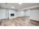 Finished basement featuring a charming brick fireplace and wood flooring at 7055 S Costilla St, Littleton, CO 80120
