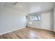 Clean bedroom with hardwood floors, closet, and a window with a view of the surrounding trees at 7055 S Costilla St, Littleton, CO 80120