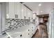 Modern kitchen featuring white cabinets, sleek countertops, and a stylish tile backsplash at 7055 S Costilla St, Littleton, CO 80120