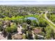 Breathtaking aerial view showcasing a home's location within a lush neighborhood and near a tranquil pond at 6862 Independence Ct, Arvada, CO 80004