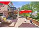 Spacious brick patio with lounge chairs, umbrellas, and spiral staircase at 6862 Independence Ct, Arvada, CO 80004