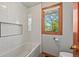 Cozy bathroom with white subway tile in shower and wooden-framed window bringing the outdoors in at 6862 Independence Ct, Arvada, CO 80004