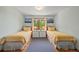 Comfortable bedroom featuring two twin beds, hardwood floors, matching nightstands and picturesque landscape art at 6862 Independence Ct, Arvada, CO 80004