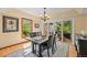 Elegant dining room featuring a modern chandelier, large windows, and access to an outdoor balcony at 6862 Independence Ct, Arvada, CO 80004