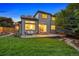 Beautifully landscaped backyard with green grass, patio, mature trees, and a charming outdoor seating area at 7114 S Acoma Way, Littleton, CO 80120