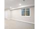 Finished basement with a window and white walls that offer bright natural light to the space at 7114 S Acoma Way, Littleton, CO 80120