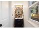 Stylish powder room featuring a modern vanity, elegant mirror, light fixture, and floral wallpaper at 7114 S Acoma Way, Littleton, CO 80120