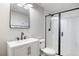 Modern bathroom with a white vanity, a black framed mirror, and a shower with black trim at 7114 S Acoma Way, Littleton, CO 80120