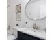 Bathroom with tub-shower combo, modern sink and vanity, round mirror, and neutral decor, offering a refreshing space at 7114 S Acoma Way, Littleton, CO 80120