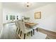 Open-concept dining area adjacent to living room, bathed in light with a modern table set for four at 7114 S Acoma Way, Littleton, CO 80120